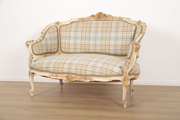 A FRENCH PAINTED AND PARCEL GILT TWO SEAT SETTEE