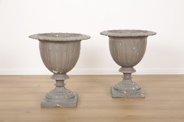 A PAIR OF GREY-PAINTED CAST IRON URNS