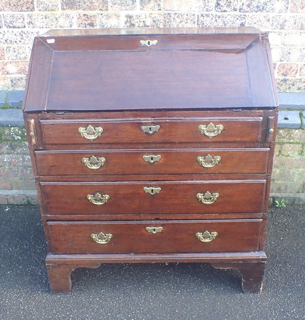 A GEORGE III OAK BUREAU OF SMALL PROPORTIONS