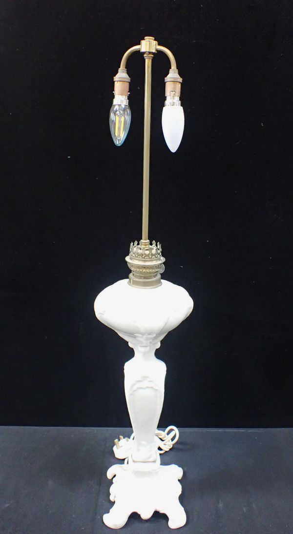 A WHITE POTTERY OIL LAMP CONVERTED TO ELECTRICITY