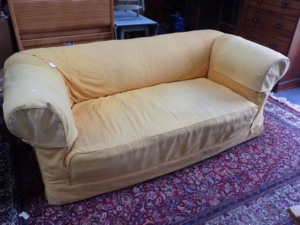 A 1920S CHESTERFIELD SOFA, WITH DROP-END, ON BUN FEET