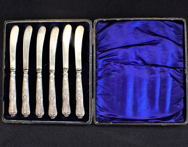 A SET OF SIX SILVER HANDLED BUTTER KNIVES