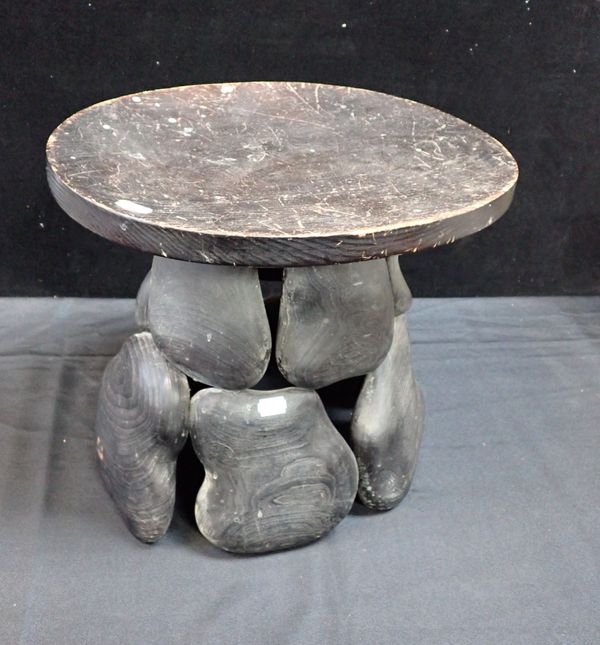 A  WOODEN STOOL OF PEBBLE FORM