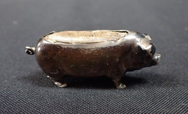 A SILVER PIG PIN CUSHION