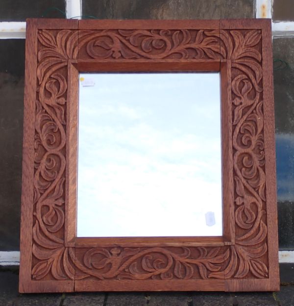 A CARVED OAK ARTS & CRAFTS STYLE MIRROR