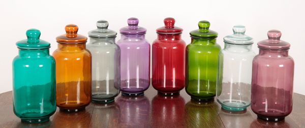 A SET OF EIGHT COLOURED AND MOULDED GLASS SWEET JARS AND COVERS