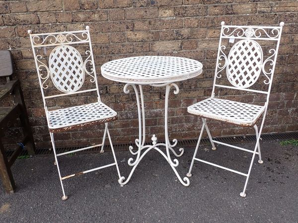 A LATTICE-WORK METAL GARDEN TABLE AND TWO CHAIRS