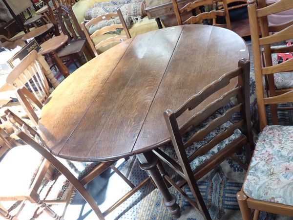 AN OAK OVAL DROPLEAF TABLE AND SIX  STAINED BEECH LADDER BACK CHAIRS