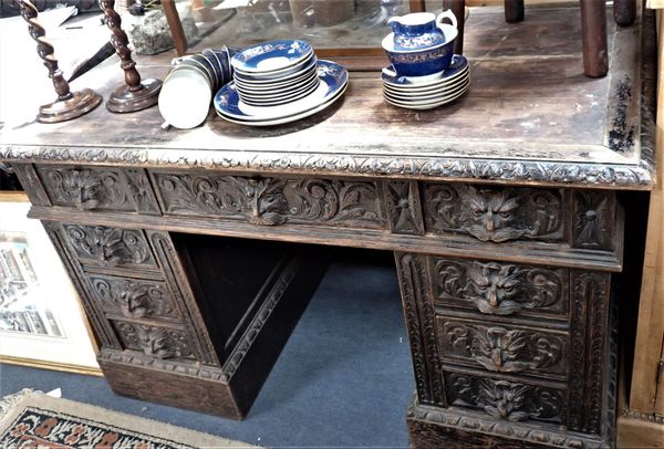 A VICTORIAN CARVED OAK PEDESTAL DESK