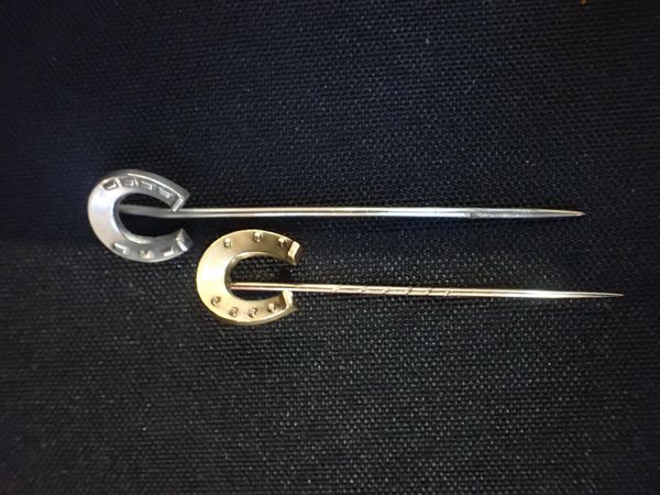 A YELLOW METAL HORSESHOE STICKPIN