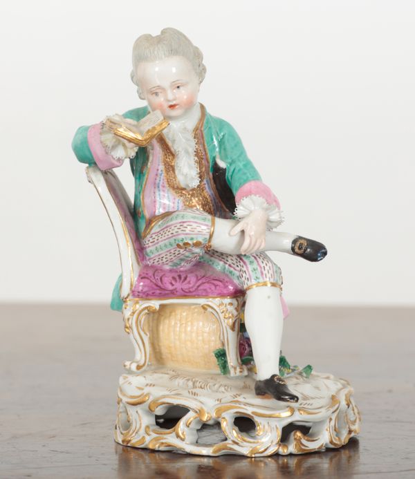 A MEISSEN PORCELAIN FIGURE OF A BOY READING