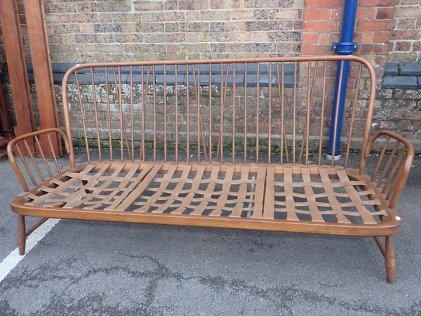 AN ERCOL STICK-BACK THREE-SEATER SOFA