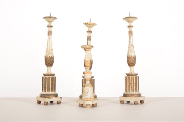 THREE  ITALIAN WHITE-PAINTED AND PARCEL GILT PRICKET CANDLESTICKS