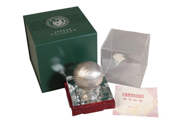 A COMMEMORATIVE SILVER SPHERE DECORATION FOR 35TH ANNIVERSARY OF THE ISSUANCE OF CHINESE PANDA GOLD COIN