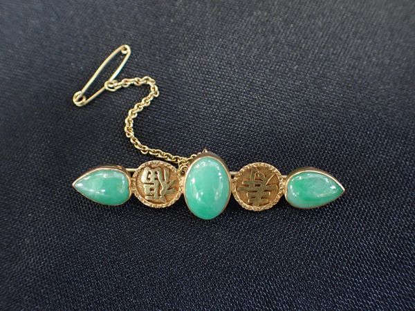 A GOLD AND JADE BROOCH