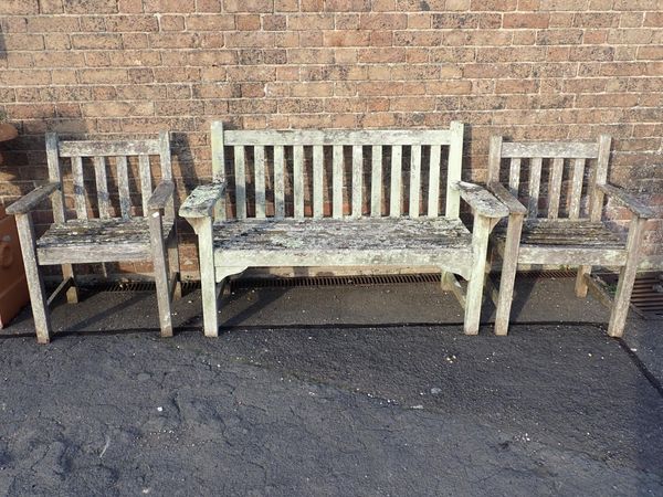 A WEATHERED AND LICHEN-ENCRUSTED TEAK GARDEN BENCH