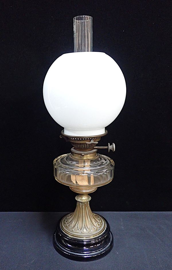 A VICTORIAN OIL LAMP WITH BRASS AND CERAMIC BASE
