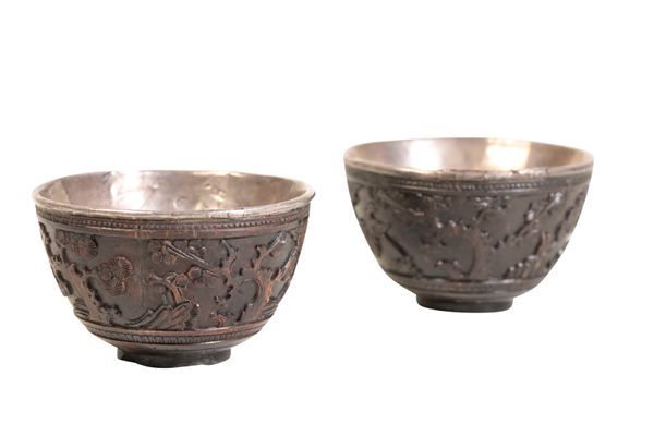 PAIR OF CARVED COCONUT AND SILVER LINED WINE CUPS, KANGXI PERIOD