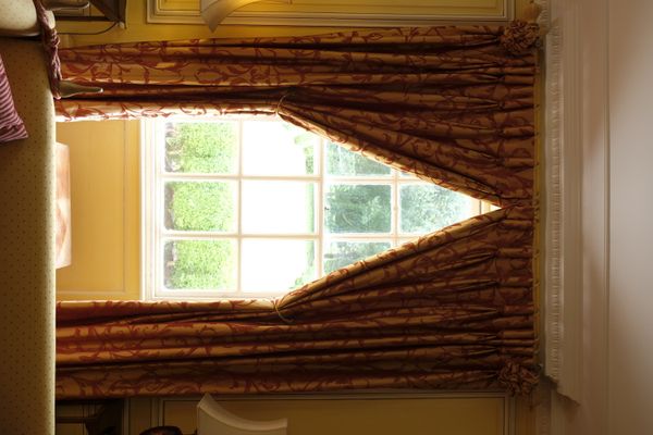 THE DRAWING ROOM CURTAINS,  GOLD FABRIC DECORATED WITH RED FLORAL MOTIFS