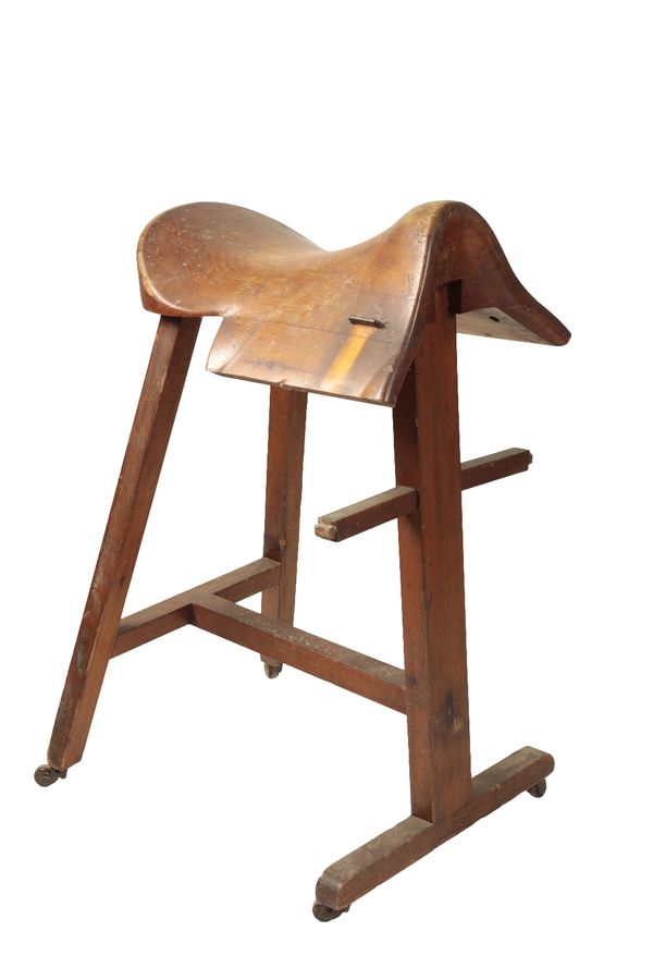 AN EDWARDIAN OAK SADDLE HORSE