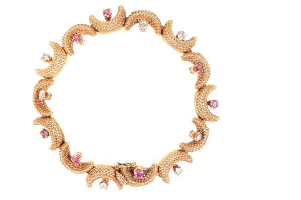 A 1960'S TIFFANY & CO CRESCENT MOON BRACELET SET WITH RUBIES AND DIAMONDS IN 18CT YELLOW GOLD