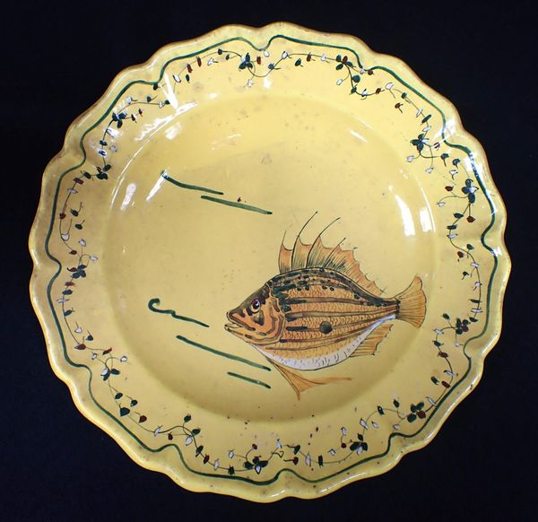 A YELLOW FAIENCE PLATE, PAINTED WITH A FISH