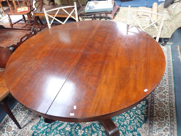 A MAHOGANY EXTENDING DINING TABLE