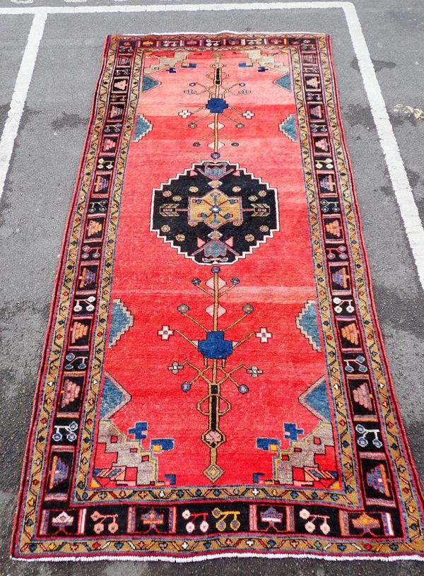 A MESHAD RUG, RED GROUND WITH CENTRAL BLACK MEDALLION
