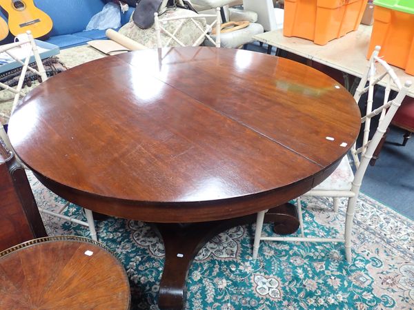 AN EXTENDING MAHOGANY CIRCULAR DINING TABLE