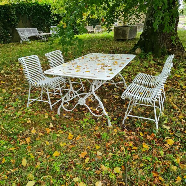 AN ARRAS STYLE WROUGHT IRON TABLE AND FOUR CHAIRS