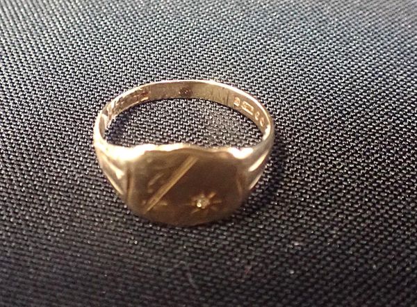 A 9ct GOLD RING, THE SHIELD-SHAPED HEAD SET WITH A SINGLE STONE