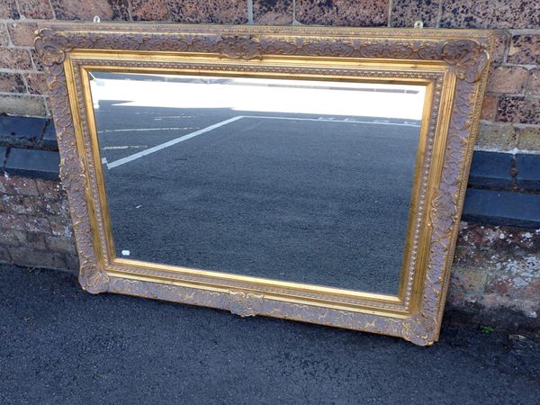 A GILT FRAMED WALL MIRROR, WITH BEVELLED PLATE
