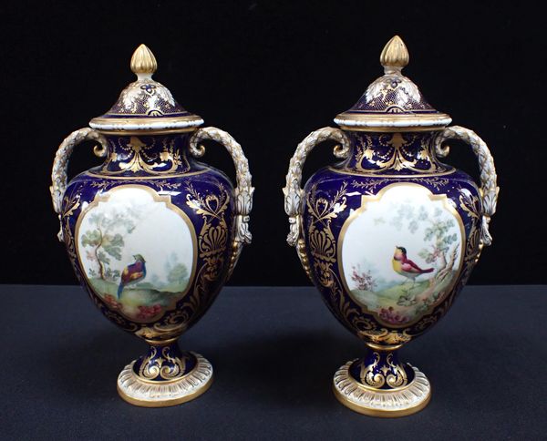 A PAIR OF ROYAL CROWN DERBY BONE CHINA URNS AND COVERS