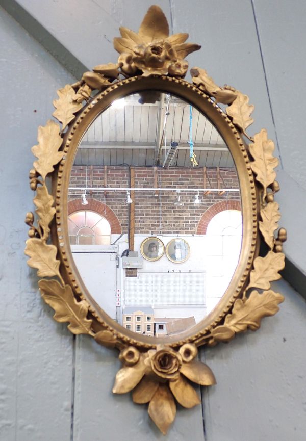 AN OVAL GILT FRAME MIRROR