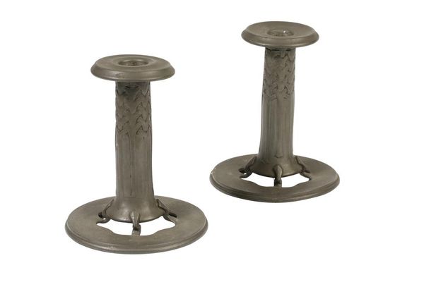 ARCHIBALD KNOX FOR LIBERTY & CO: A PAIR OF PEWTER CANDLESTICKS