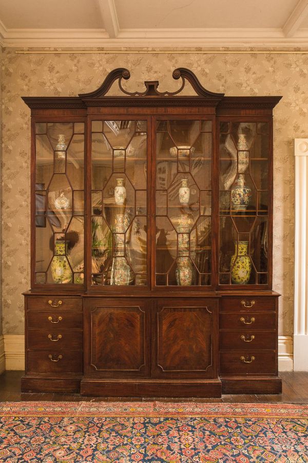 AN EARLY GEORGE III MAHOGANY BREAKFRONT BOOKCASE IN THE MANNER OF THOMAS CHIPPENDALE