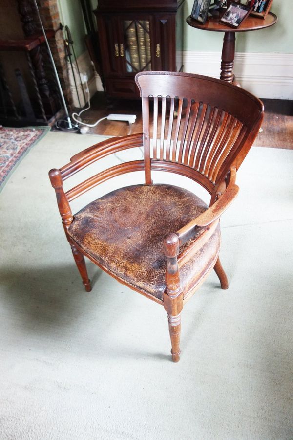 AN EDWARDIAN OAK COMB-BACK OFFICE CHAIR