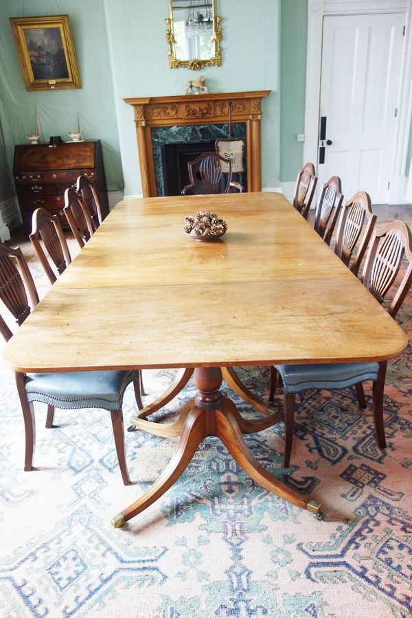 A GEORGE III STYLE MAHOGANY FOUR PILLAR DINING TABLE