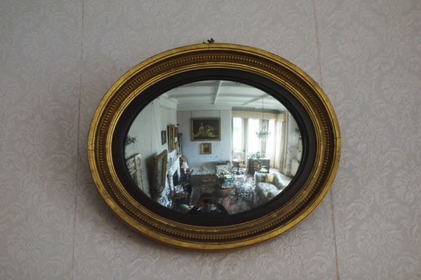 A REGENCY GILTWOOD OVAL WALL MIRROR