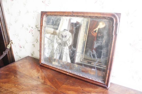 A GEORGE II WALNUT AND PARCEL-GILT WALL MIRROR