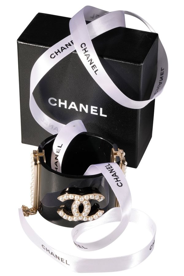 CHANEL CUFF FASHIONED IN BLACK LUCITE, WITH CENTRAL CC LOGO IN PEARL