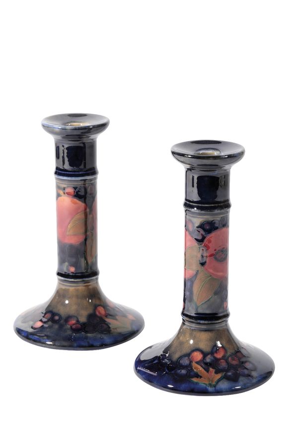 WILLIAM MOORCROFT: A PAIR OF "POMEGRANATE" CANDLESTICKS