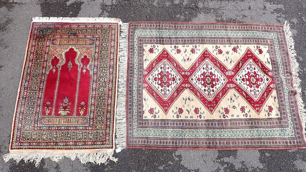 A TURKISH RUG, WOVEN IN REDS, BLUE AND GREEN