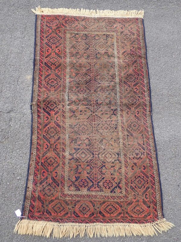 AN OLD RED GROUND  BALUCH RUG