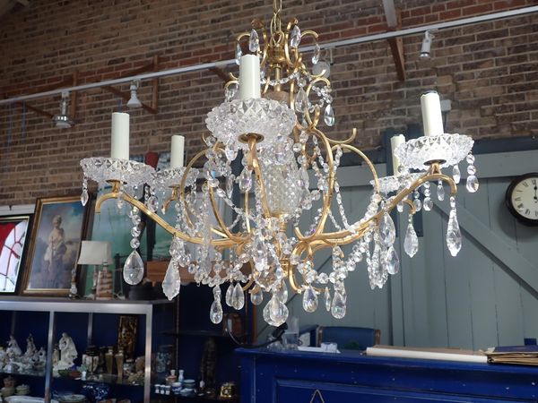 A SIX-BRANCH GILT METAL CHANDELIER WITH GLASS DROPS