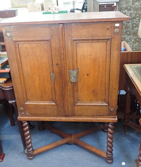 A CONTINENTAL OAK CUPBOARD ON STAND