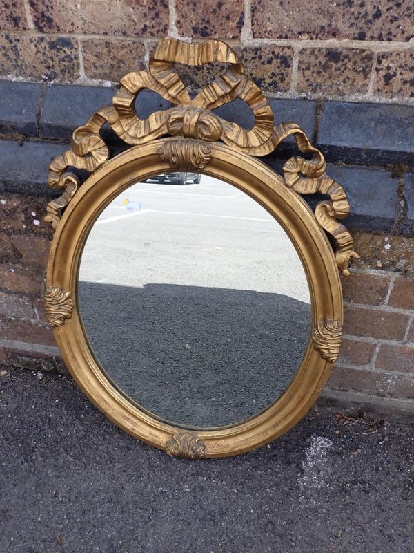 AN ITALIAN GILTWOOD OVAL WALL MIRROR