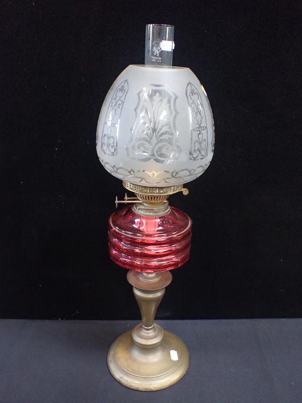 A VICTORIAN OIL LAMP WITH FACETED CRANBERRY GLASS FONT