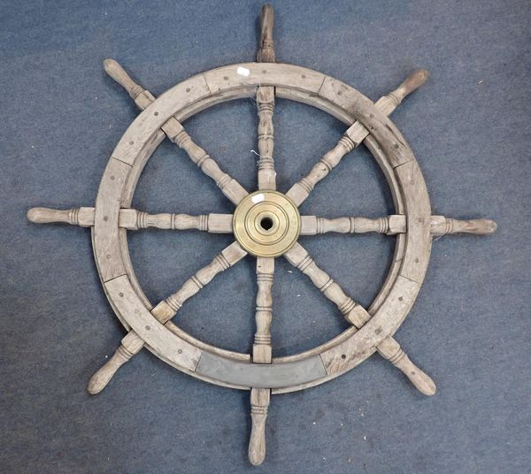A WEATHERED TEAK SHIP'S WHEEL