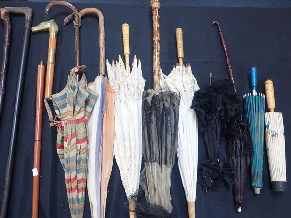 A COLLECTION OF WALKING STICKS AND UMBRELLAS